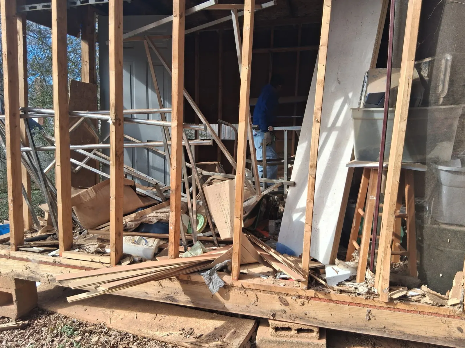 Storage shed cleanout in progress with old lumber, framing and household debris being cleared in Charlotte, NC